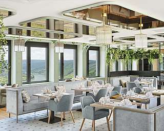 Modernes Restaurant mit Pflanzen und stilvollem Mobiliar.