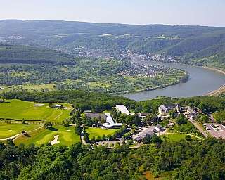 Luftaufnahme eines Golfplatzes und eines Flusses in einer grünen Umgebung.