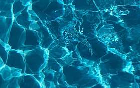 Nahaufnahme von Wasseroberfläche mit Lichtspiel und Wellen.